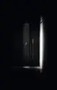 Duschbereich mit einem Wasserfall-Duschkopf, der die Wand hinunter tropft. Die Armatur ist minimalistisch und in einem modernen, dunklen Raum installiert. Ideal Standard ist der Hersteller.